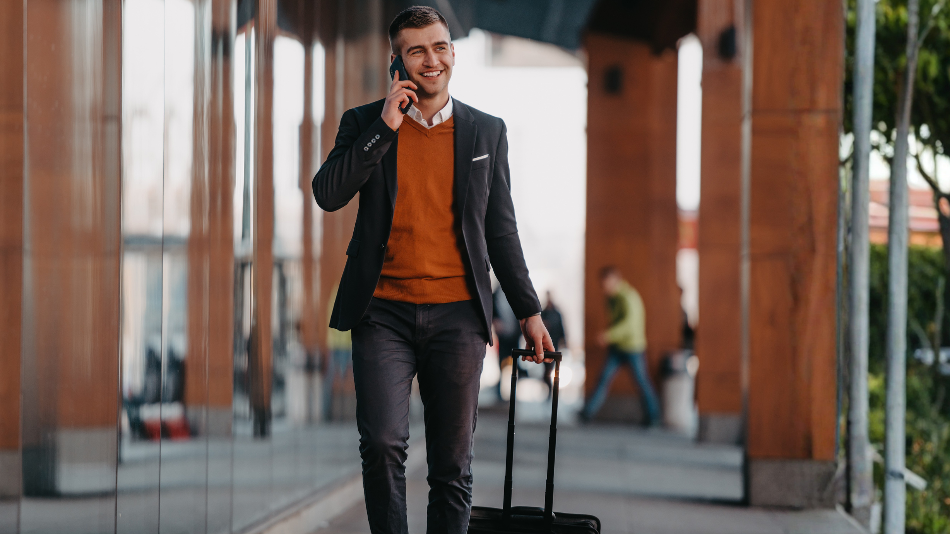 Traveller on the phone outside an airport terminal
